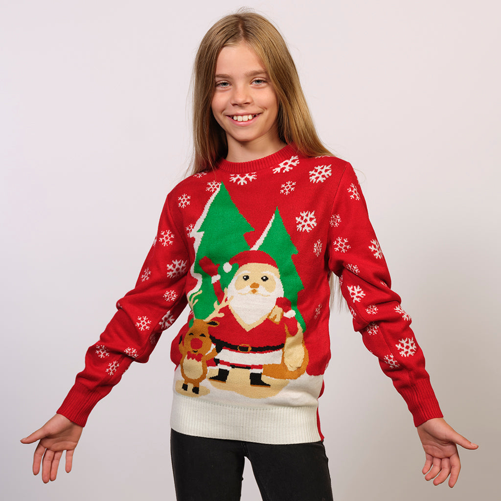 Et barn iført en rød julesweater med en julemand og juletræer.